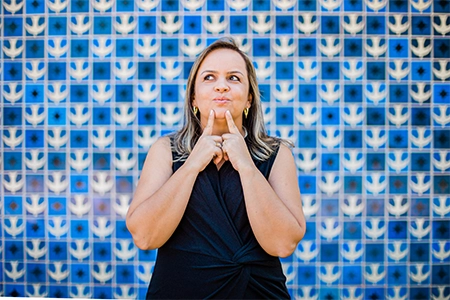 imagem da Dra Priscila olhando para cima e apontando para sua boca